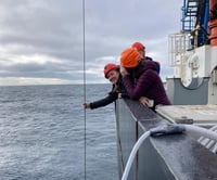 woman smiling as she holds line submerged for zooplankton sample collection
