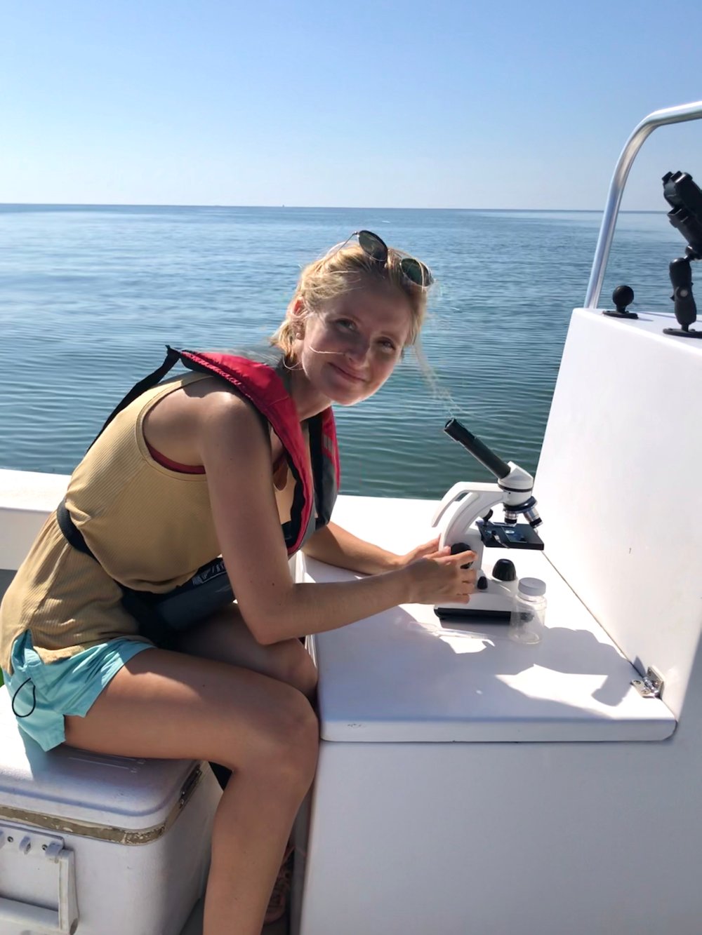Savannah Mapes using microscope on boat