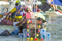 People in diy boats on a lake